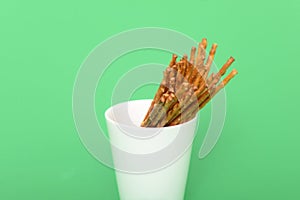 Heap of salted sticks in a white cup