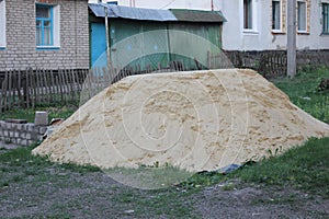 Heap of sand on grassy soil