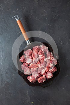 Heap small pieces raw meat in frying pan