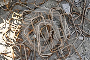 A heap of steel bar for structure covering by rust on the cocrete floor in front the building in construction