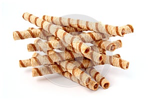 Heap of striped wafer tubules with the chocolate cream, isolated