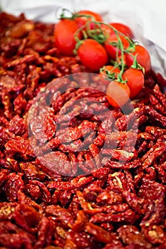 Heap of sundried tomatoes with fresh tomatoes