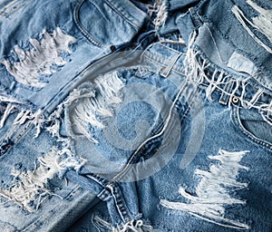 Heap of torn and frayed, threadbare jeans