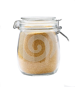 Heap of uncooked dry amaranth grains in glass storage jar isolated on white background