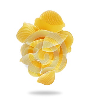 Heap of uncooked shell pasta in the air close up on a white background