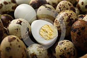 Heap of unpeeled and peeled hard boiled quail eggs as background, closeup
