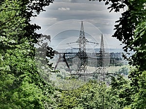 From a heap a view, framed by green trees, typical landscape of the Ruhr area in Germany, framework of a coal winding tower and