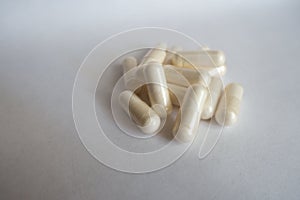 Heap of white capsules of Acetyl L-Carnitine photo