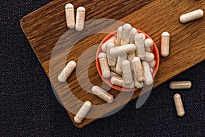 Heap of white capsules close-up. niacin dietary supplement capsules on wooden board. immune support medical concept
