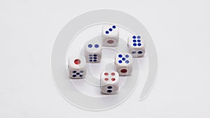 Heap of white cubic dice with blue and red spikes dots on a white background.