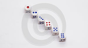 Heap of white cubic dice with blue and red spikes dots on a white background.