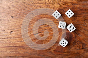 Heap of white dice on rustic wooden table top view. Gambling devices. Game of chance concept.