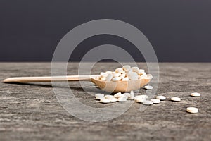 Heap of white pills on colored background. Tablets scattered on a table. Pile of red soft gelatin capsule. Vitamins and