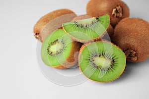 Heap of whole and cut fresh kiwis on white background, closeup. Space for text