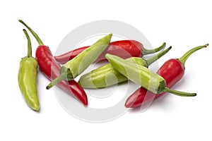 Heap of whole fresh raw green and red rawit peppers close up on white background