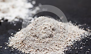 Heap of whole grain flour on the black. Selective focus, macro