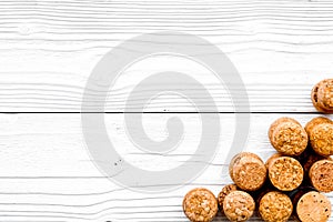 Heap of wine bottle corks on white wooden background top view copyspace