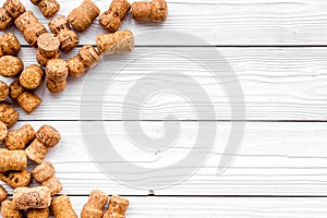 Heap of wine bottle corks on white wooden background top view copyspace