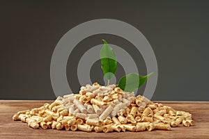 Heap of wooden pellets biofuel on wooden table close up