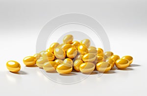 Heap of yellow oval capsules on white background