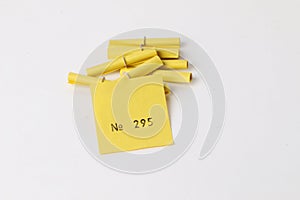 Heap of yellow tombola tickets are lying in the white studio with an open winning number