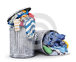 Heaps of clothes in iron dumpsters isolated on a white background.