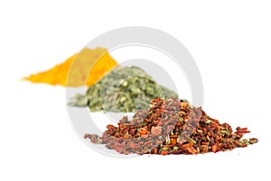 Heaps of various ground spices on white
