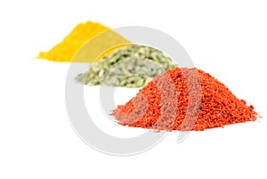 Heaps of various ground spices on white