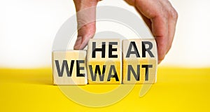 We hear and want symbol. Concept words We hear we want on wooden cubes. Businessman hand. Beautiful yellow table white background