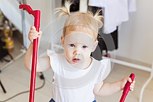 Hearing aid in baby girl`s ear. Toddler child wearing a hearing aid at home. Disabled child, disability and deafness