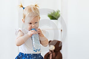 Hearing aid in baby girl`s ear. Toddler child wearing a hearing aid at home. Disabled child, disability and deafness