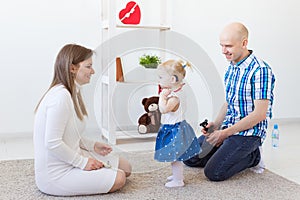 Hearing aid in baby girl`s ear. Toddler child wearing a hearing aid at home. Disabled child, disability and deafness