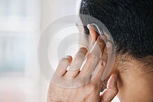 Hearing aid, face and ear of man with disability from the back on mockup space. Closeup of deaf person, medical device