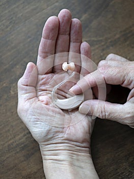 Hearing aid in hand. Assistive listening or alerting devices. World hearing day photo