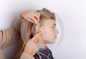 Hearing aid inserting in a young girl ear