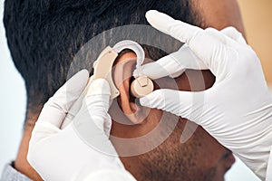 Hearing aid, man and doctor hands with deaf patient consultation for ear and wellness at hospital. Help, employee and