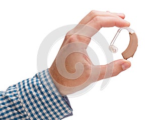 Hearing aid in a man`s hand. Isolated on white background.