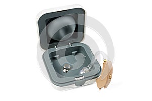 Hearing aid part in a box and part outside close-up on a white isolated background