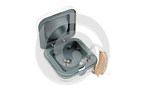 Hearing aid part in a box and part outside on a white isolated background