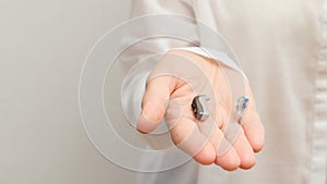 Hearing aids. Young Female Doctor Showing Hearing Aid To Patient