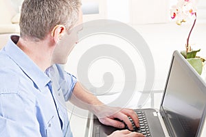 Hearing impaired man working with laptop
