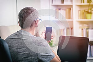 Hearing impaired man working with laptop and mobile phone