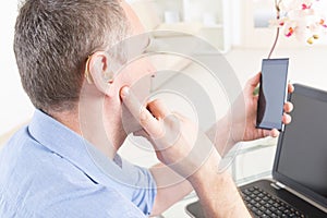 Hearing impaired man working with laptop and mobile phone