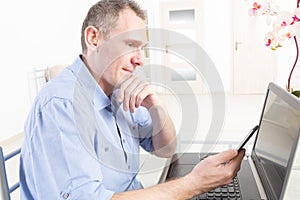 Hearing impaired man working with laptop and mobile phone