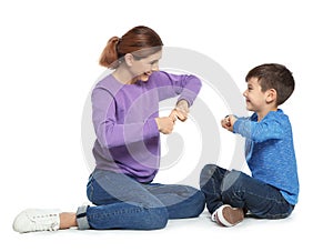 Hearing impaired mother and her child talking with help of sign language on white