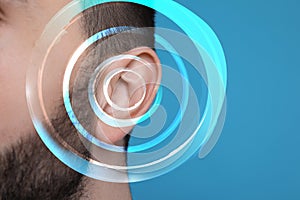 Hearing loss concept. Man and sound waves illustration on light blue background, closeup