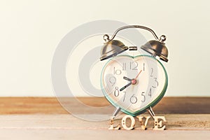 Heart alarm clock with love word love on table