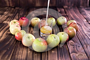 Heart of apples on brown wooden background. Apple juice on wooden table