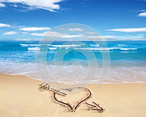 Heart with arrow, as love sign, drawn on the beach shore, with t