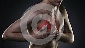 Heart attack, man with chest pain on black background